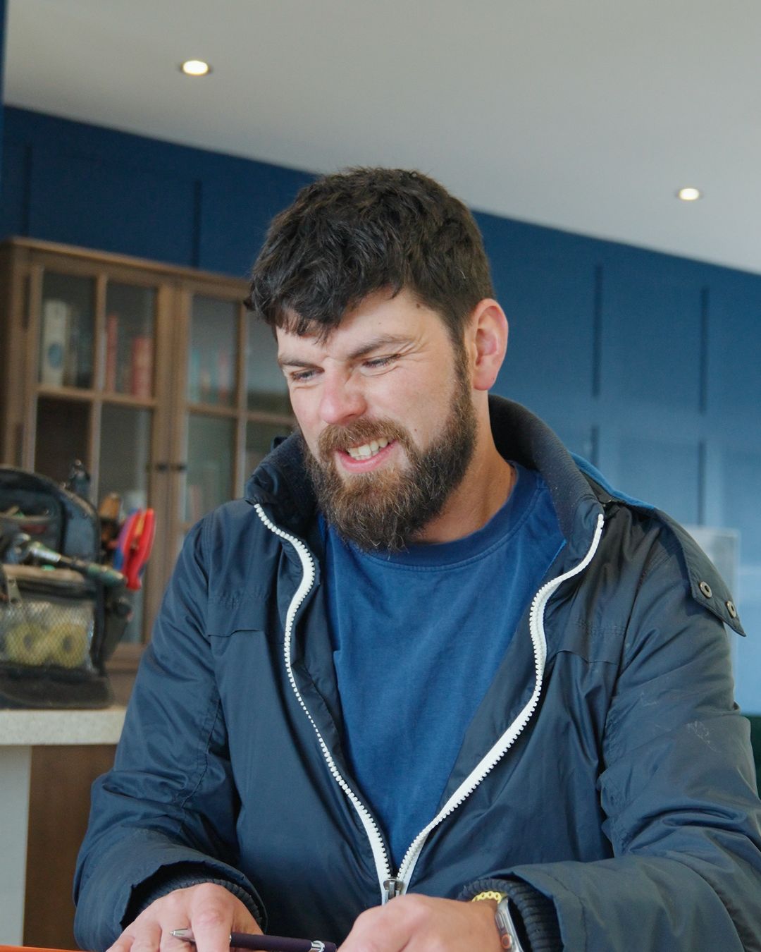 Heating engineer filling in job paperwork at the kitchen table