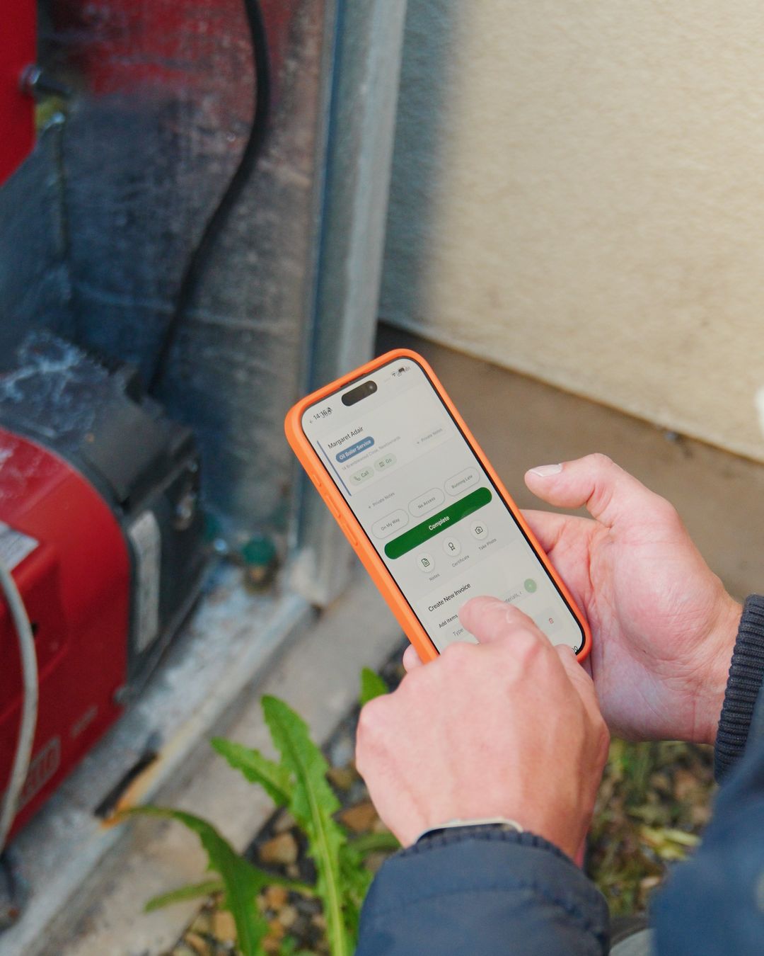 Engineer using WorkMate Pro on his phone at the boiler on a real job