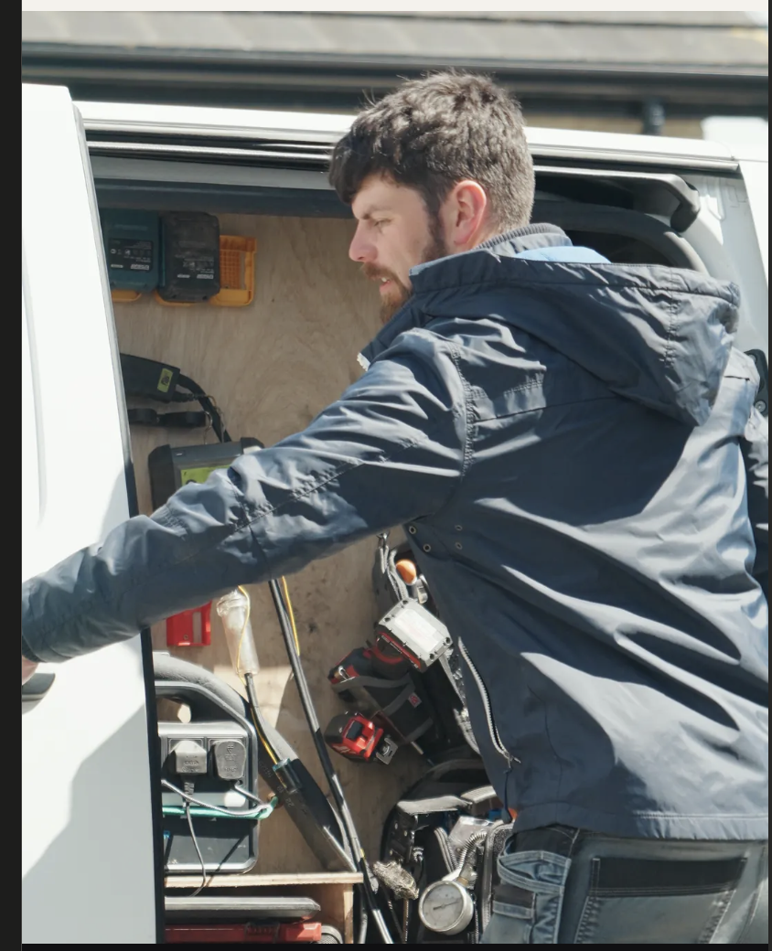 Engineer reaching into the back of his van for tools
